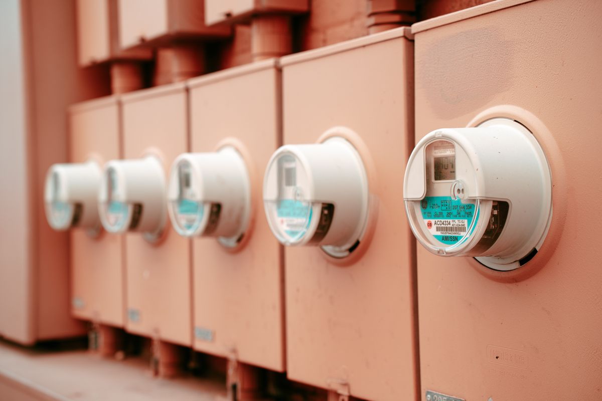 Row of electric meters on the side of a multi-unit building